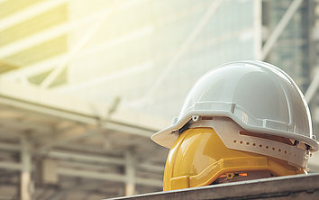 Two construction helmets in front of a skyscraper