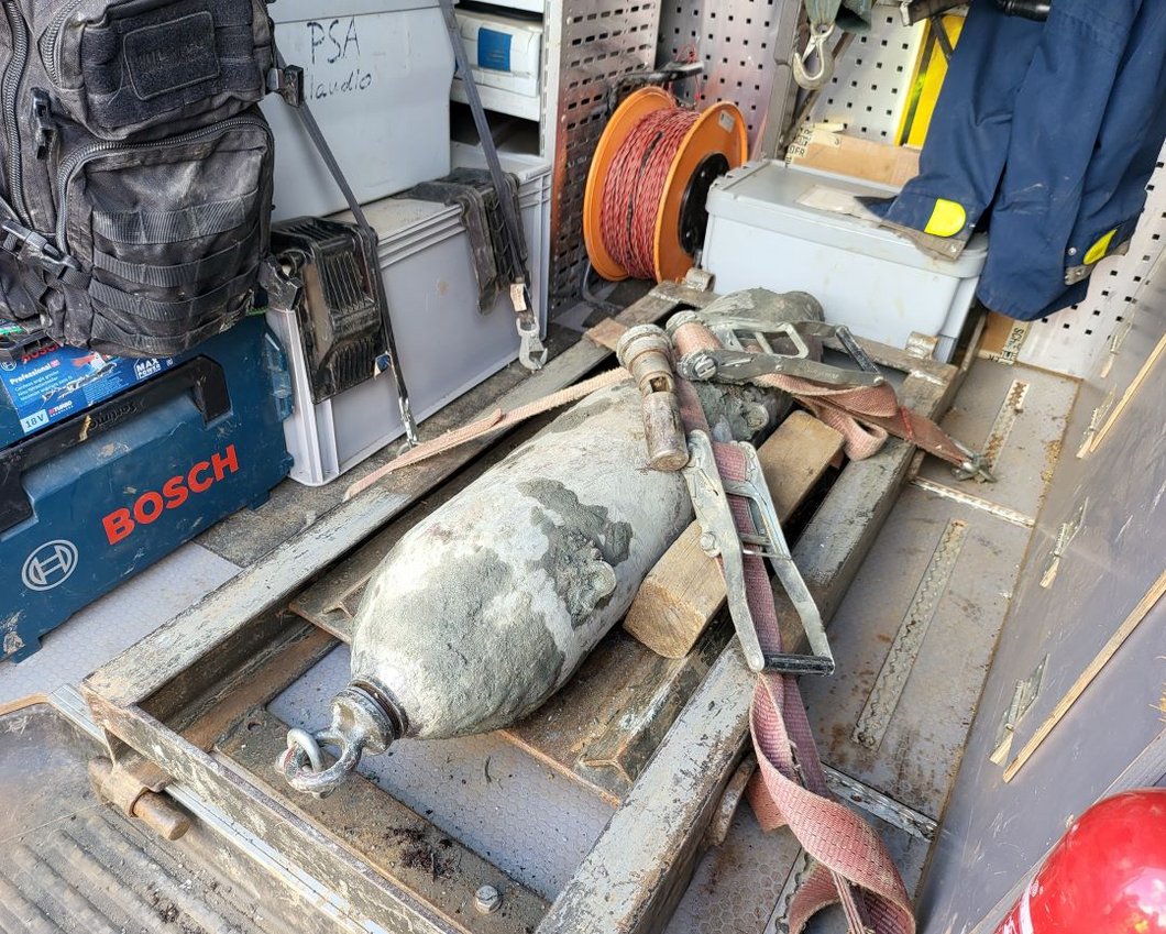 Auf dem Bild ist eine längliche Bombe zu sehen, die in einer Transporter festgeschnallt ist.
