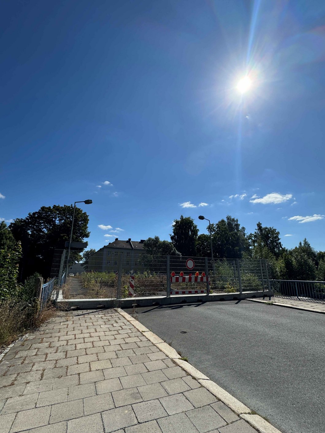 Auf dem Bild ist eine bewachsene Brücke mit Absperrung zu sehen.
