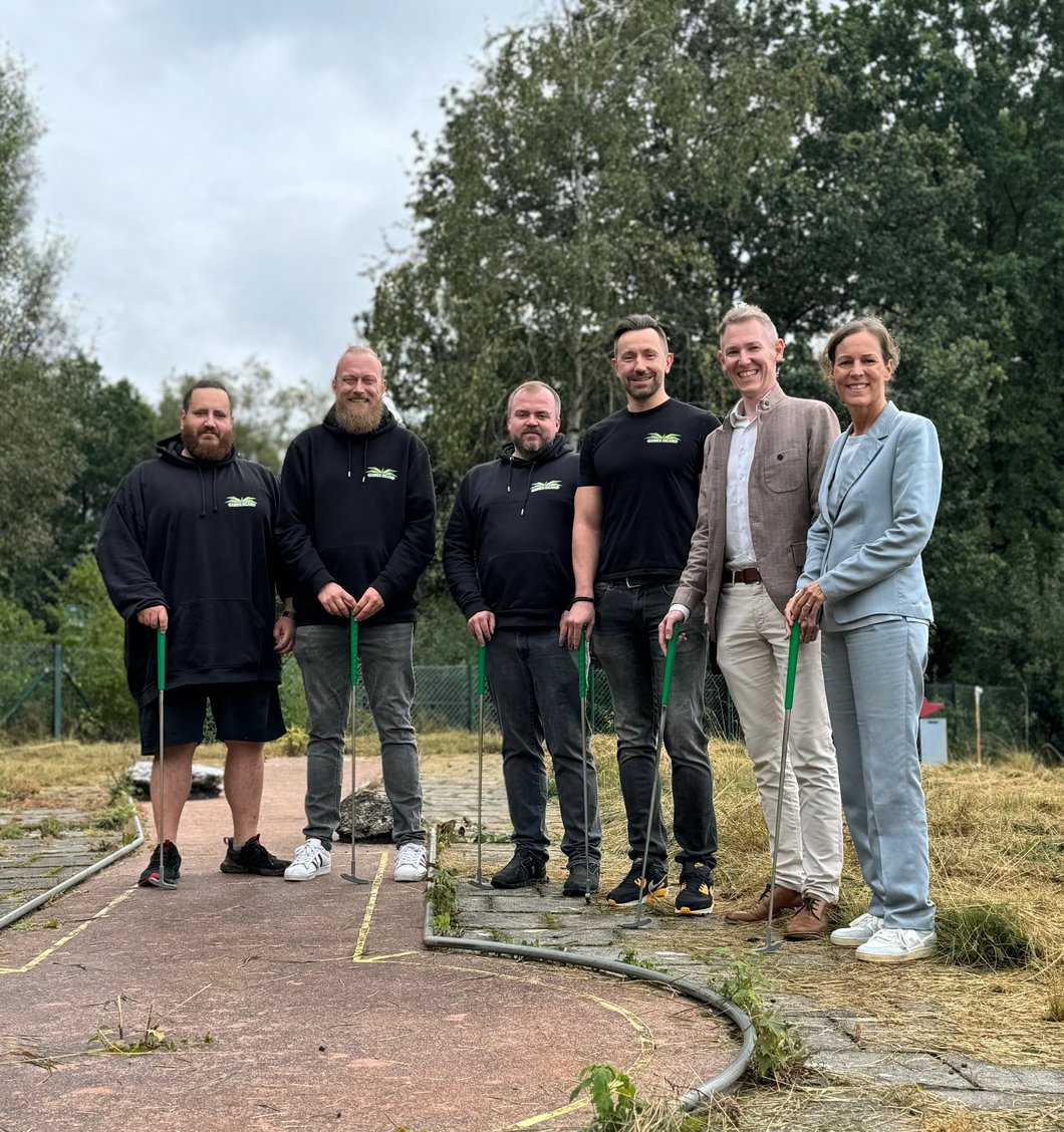 Auf dem Bild sind sechs Personen mit Minigolf-Schlägern zu sehen.