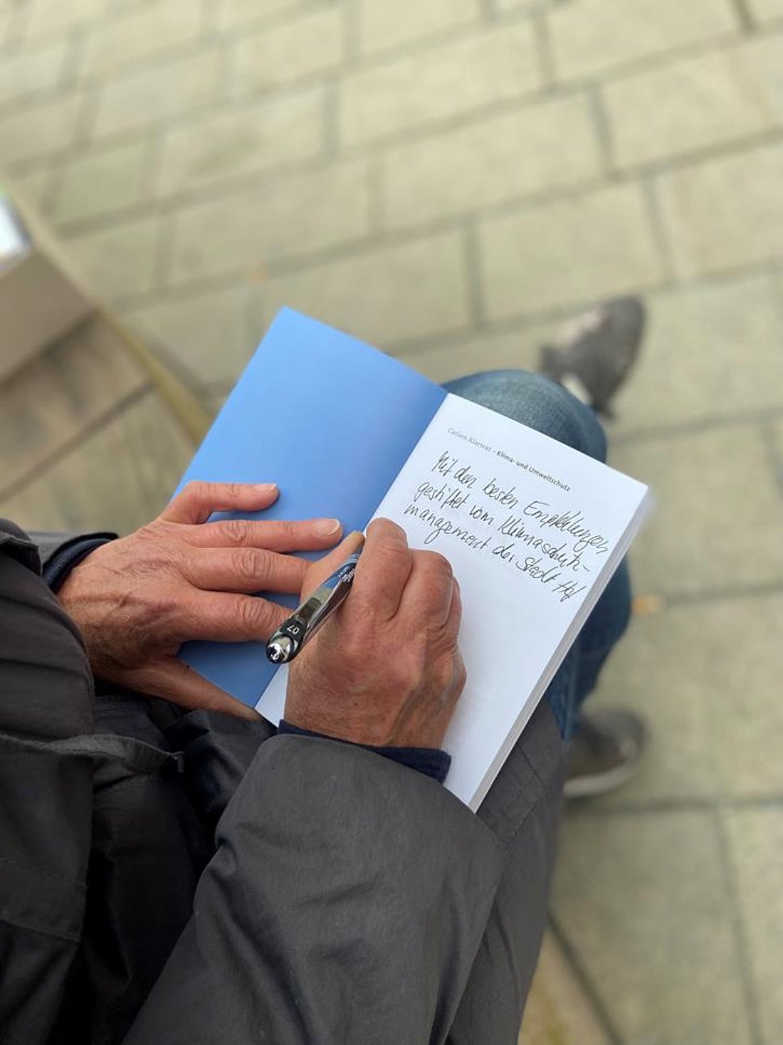 Auf diesem Foto schreibt eine Person in ein Buch