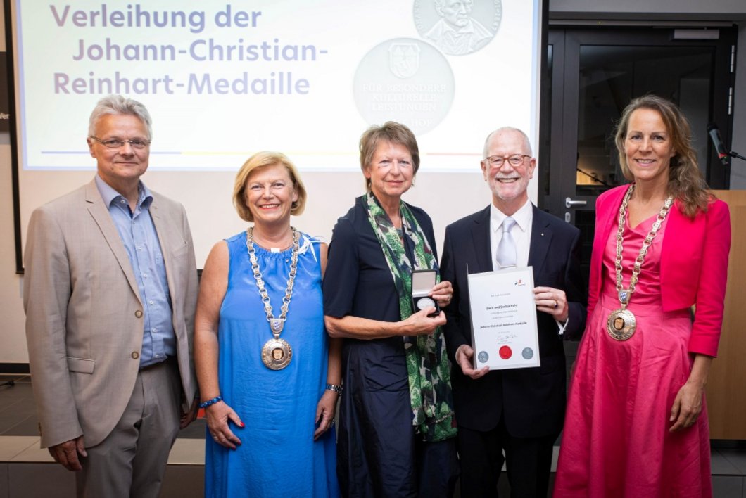 Auf dem Bild sind drei Frauen und zwei Männer zu sehen. Ein Paar hält Urkunde und Medaille in den Händen.