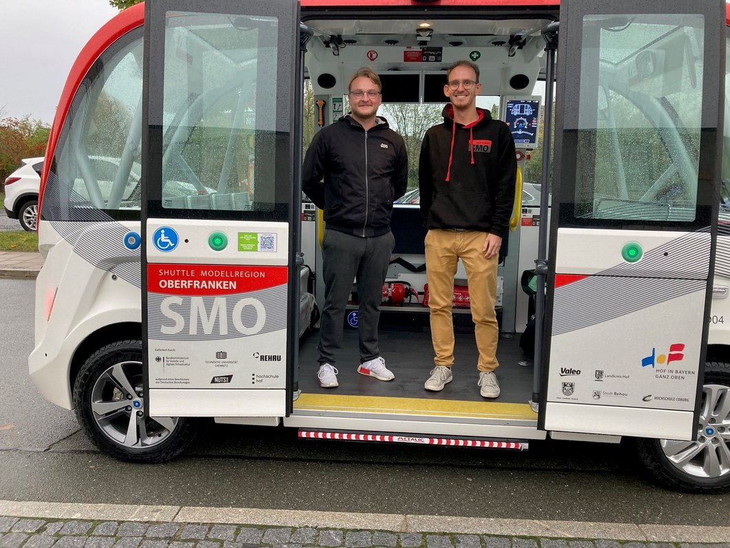 Auf dem Bild sind zwei Männer zu sehen, die in einem Shuttle stehen.
