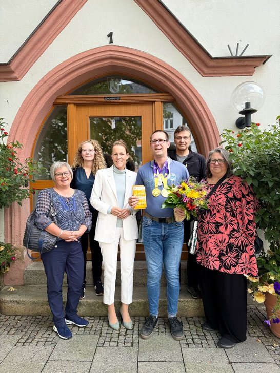 Auf dem Bild sieht man mehrere Personen vor dem Eingang des Hofer Rathauses.