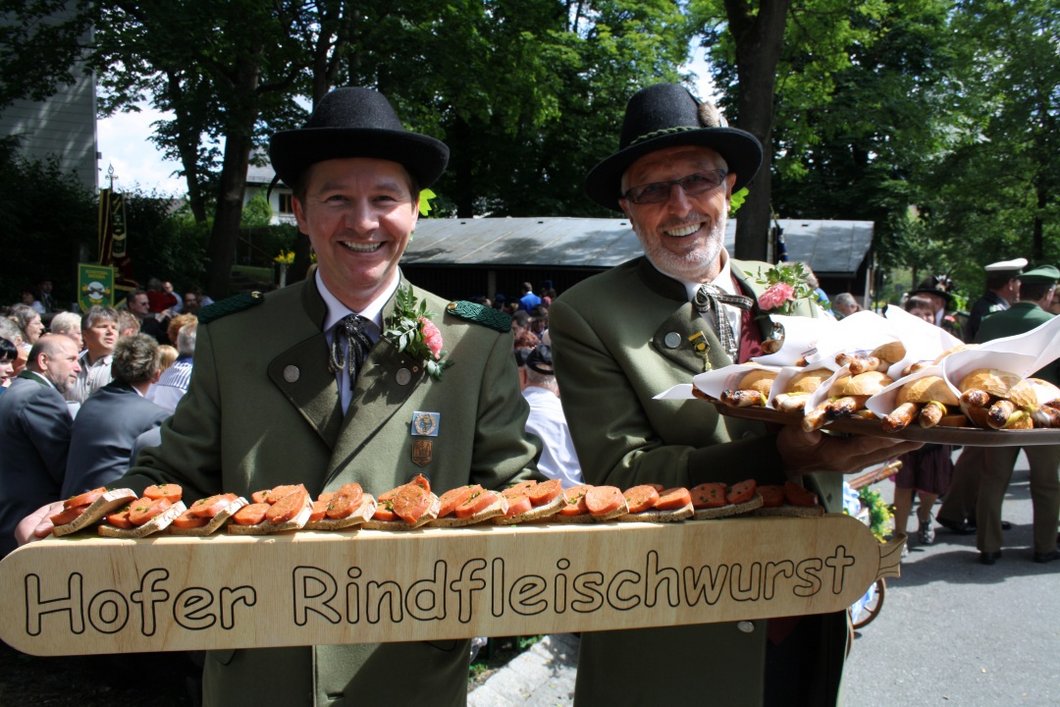 Zwei Männer präsentieren Rindfleischwurst zum Verkauf.