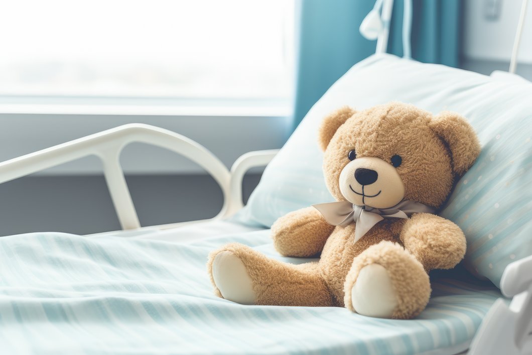 Ein Teddy liegt auf einem Krankenhausbett