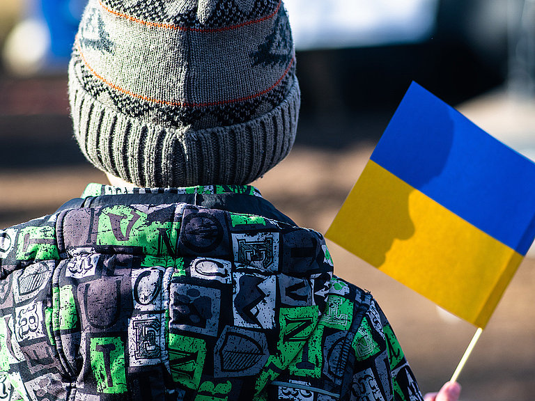 Foto von einem Kind mit einer Ukraine Flagge