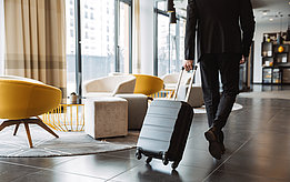 Mann zieht einen Koffer im Hotel