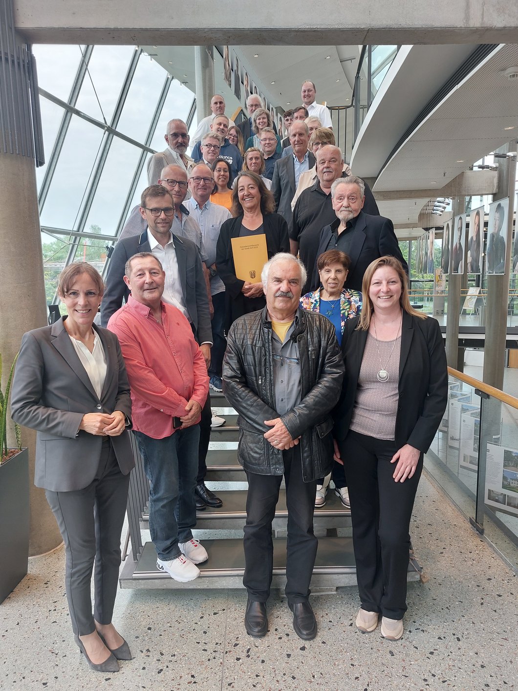 Auf dem Bild sind fast 30 Menschen zu sehen, die auf einer Treppe stehen.