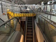 Auf dem Bild ist eine Baustelle im Obergeschoss eines Gebäudes zu sehen, im Vordergrund eine Rolltreppe.