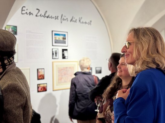 Auf dem Bild sind Menschen zu sehen, die sich die Kunstausstellung ansehen.