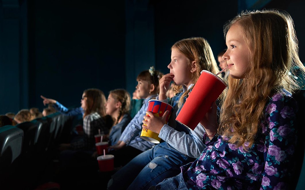 Auf diesem Foto sehen Kinder einen Film im Kino