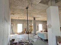 Auf dem Bild ist ein Innenraum zu sehen, der sich im Umbau befindet. Kabel und Baumaterialien liegen herum.