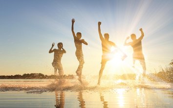 Freunde tanzen am Wasser