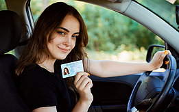 Foto von einem Mädchen mit ihrem Führerschein in ihrer Hand