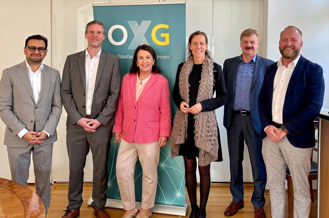 Auf dem Foto sind sechs Personen vor einem OXG-Aufsteller zu sehen.
