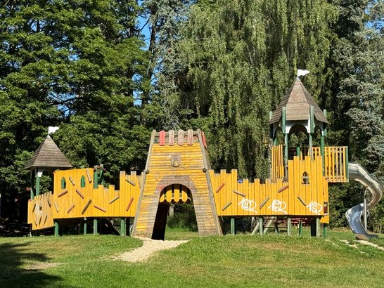 Auf dem Bild ist eine große Spielburg aus Holz zu sehen.
