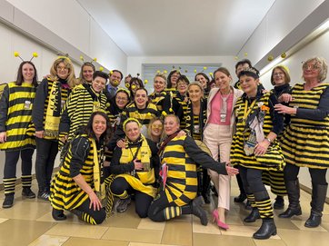Auf dem Foto sind zwanzig Frauen im Bienenkostüm mit der Oberbürgermeisterin und zwei Männern zu sehen.