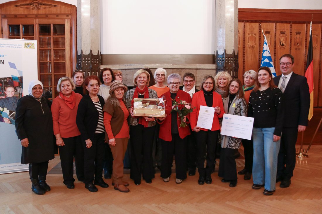 Auf dem Bild sind mehr als 15 Frauen zu sehen, mit Blumen und Urkunden.