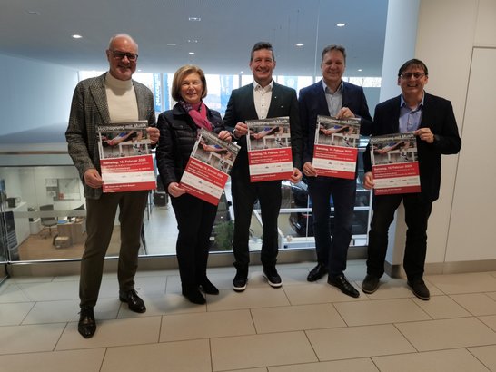 Auf dem Foto sind fünf Personen zu sehen, die Veranstaltungsplakate hochhalten.