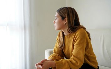 Frau sitzt vor dem Fenster