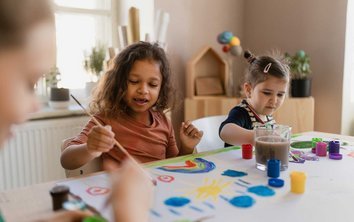 Auf diesem Foto malen Kinder in der Kinderbetreuung