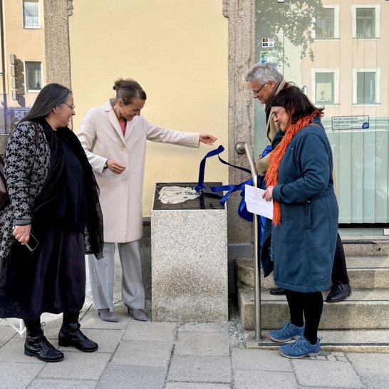 Auf dem Bild sind vier Personen zu sehen, die um eine Infostele stehen.