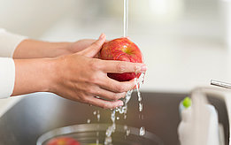 Apfel unter Leitungswasser waschen