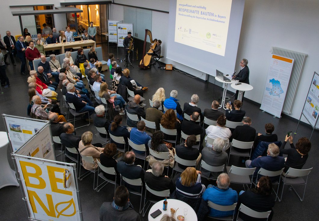 Mehrere Dutzend Menschen in einem großen Saal hören einem Redner zu.