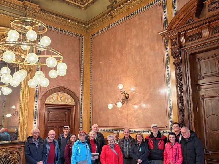 Auf dem Bild sieht man Seniorinnen und Senioren in einem prachtvollen Saal