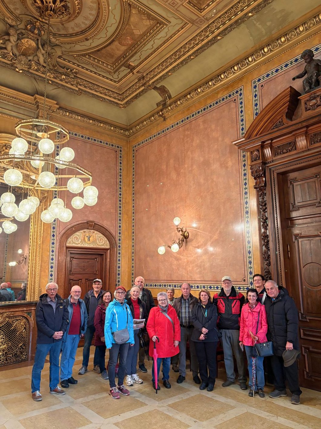 Auf dem Bild sieht man Seniorinnen und Senioren in einem prachtvollen Saal