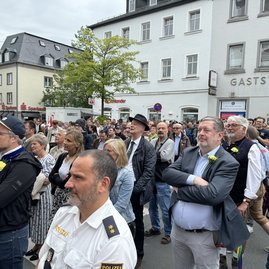 Eine Menschenmenge steht auf der Straße und hört zu.