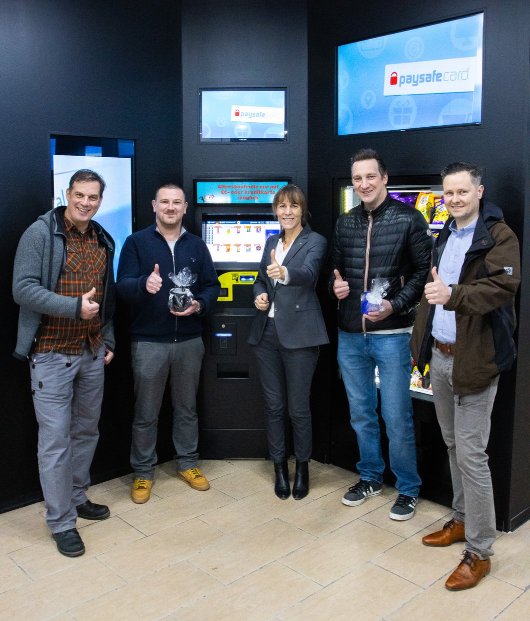 Carsten Reichel, Stadtmarketing Hof, Stefan Linke, Inhaber und Geschäftsführer 24-h-Kiosk, Eva Döhla, Oberbürgermeisterin, Alexander Jahn, Inhaber und Geschäftsführer 24-h-Kiosk, Christian Weigand, Immobilienoffensive Stadt Hof halten den Daumen hoch im neuen Automatenkiosk 
