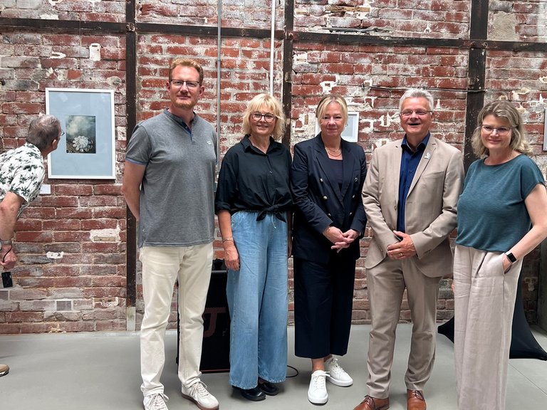 Auf dem Bild sieht man mehrere Menschen in einer Kunstausstellung