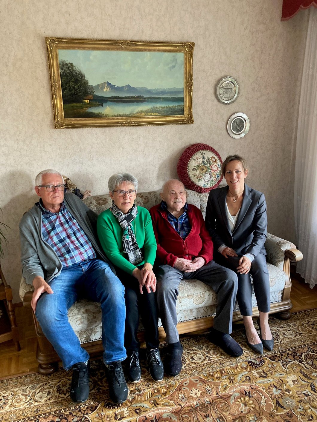 Auf dem Foto sind zwei Frauen und zwei Männer zu sehen, die auf einem Sofa sitzen.