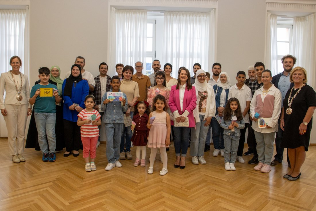 Auf dem Bild sind circa 30 Personen zu sehen, die nebeneinanderstehen. Zwei Frauen tragen Amtsketten