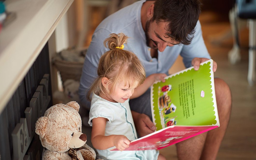 Kind liest mit dem Vater