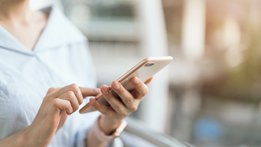 Woman typing something into her mobile phone