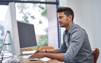 Auf diesem Foto arbeitet ein Mann am Computer