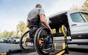 Man in wheelchair is lifted into car 