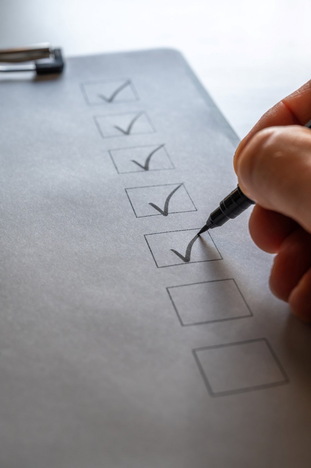 Auf dem Bild wird eine Checkliste abgehakt.