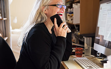 Auf diesem Foto ist eine lachende Frau am Telefon zu sehen