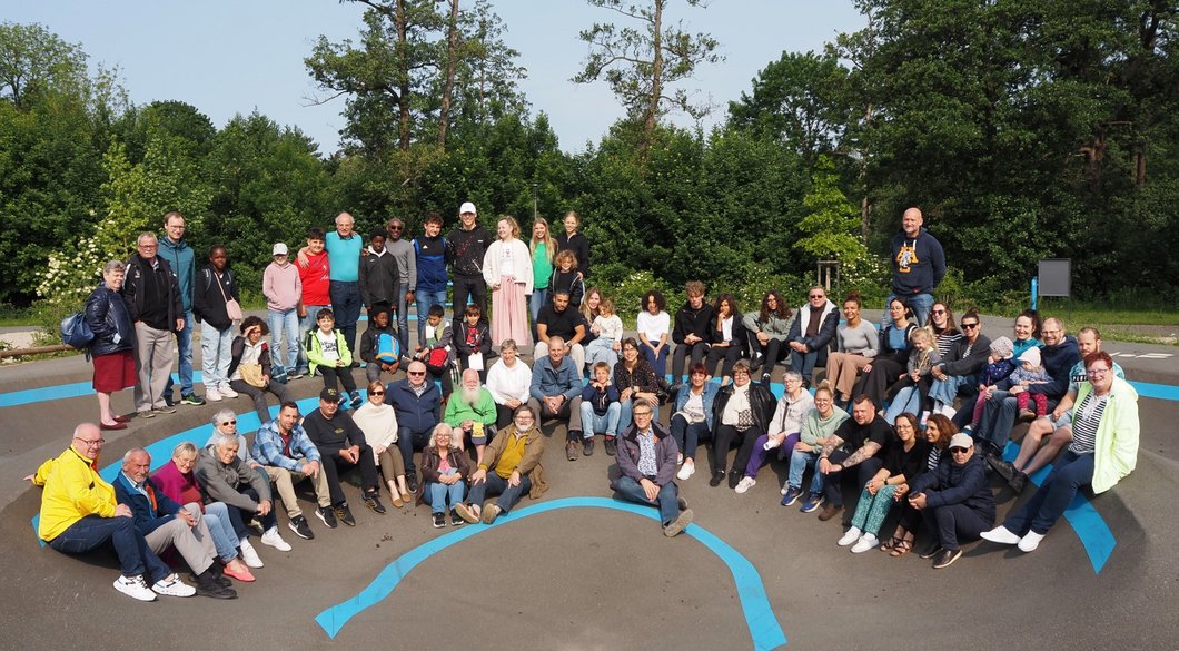 Auf dem Bild sind Dutzende Menschen verschiedenen Alters in einem Skatepark zu sehen.