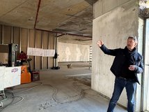 Auf dem Bild ist ein Mann zu sehen, der in einem Innenraum steht, der im Umbau ist.