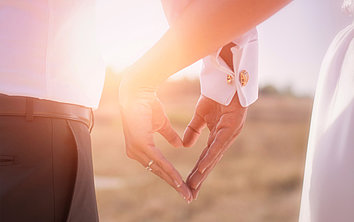 Ein Brautpaar bildet ein Herz mit den Händen